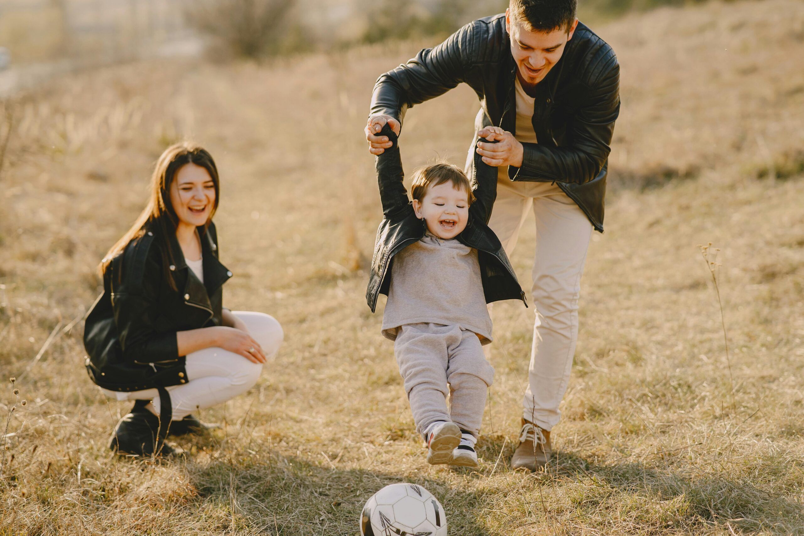 A family with a young child playing soccer